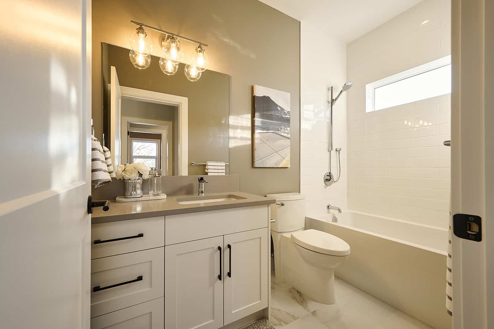 Modern Victoria BC ensuite bathroom with tub, vanity, and neutral tones.