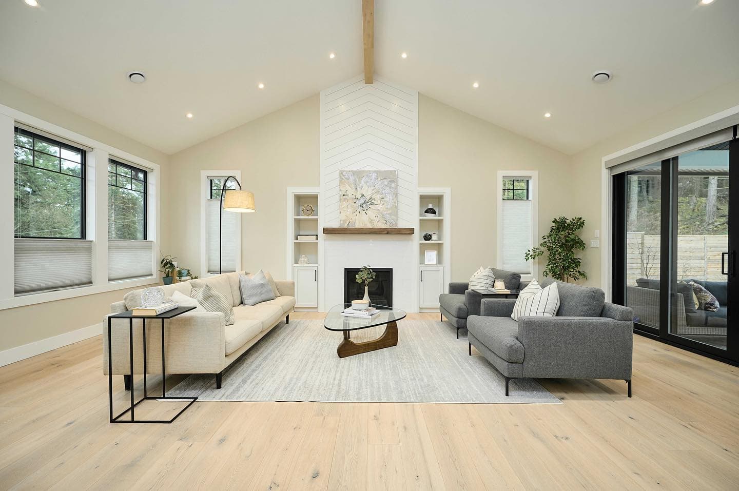 Bright living room with neutral tones, wood floors, and a fireplace in a White Wolf Homes custom YVR.