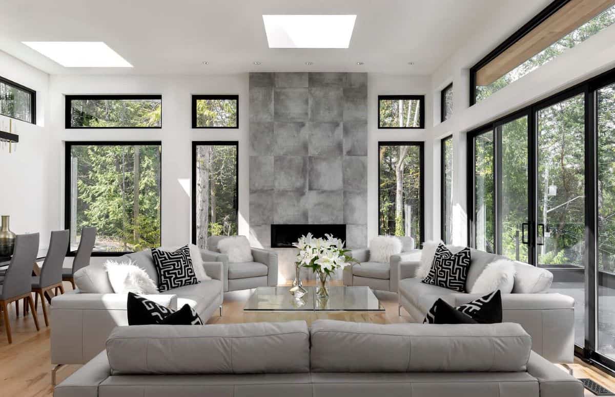 Modern living room with large glass windows and a central fireplace in a White Wolf Homes design.