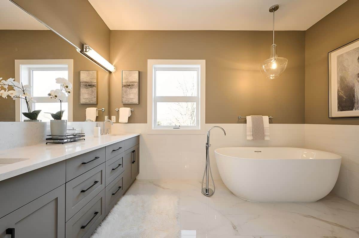 Modern freestanding bathtub in a spacious ensuite with double vanity and neutral tones.