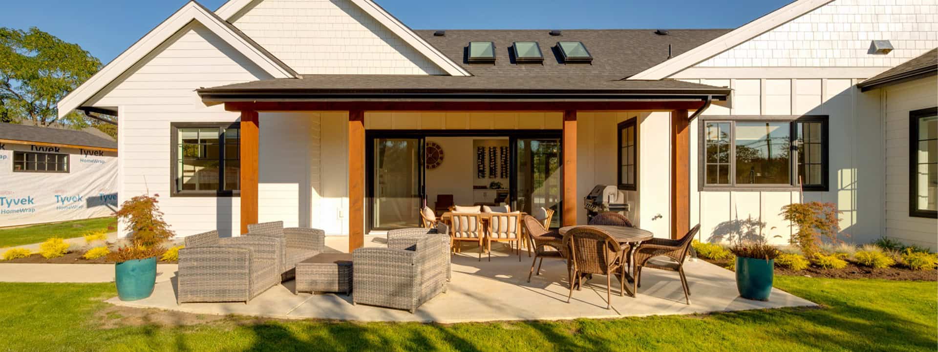 Modern Victoria BC custom home by White Wolf Homes with patio seating and yard.