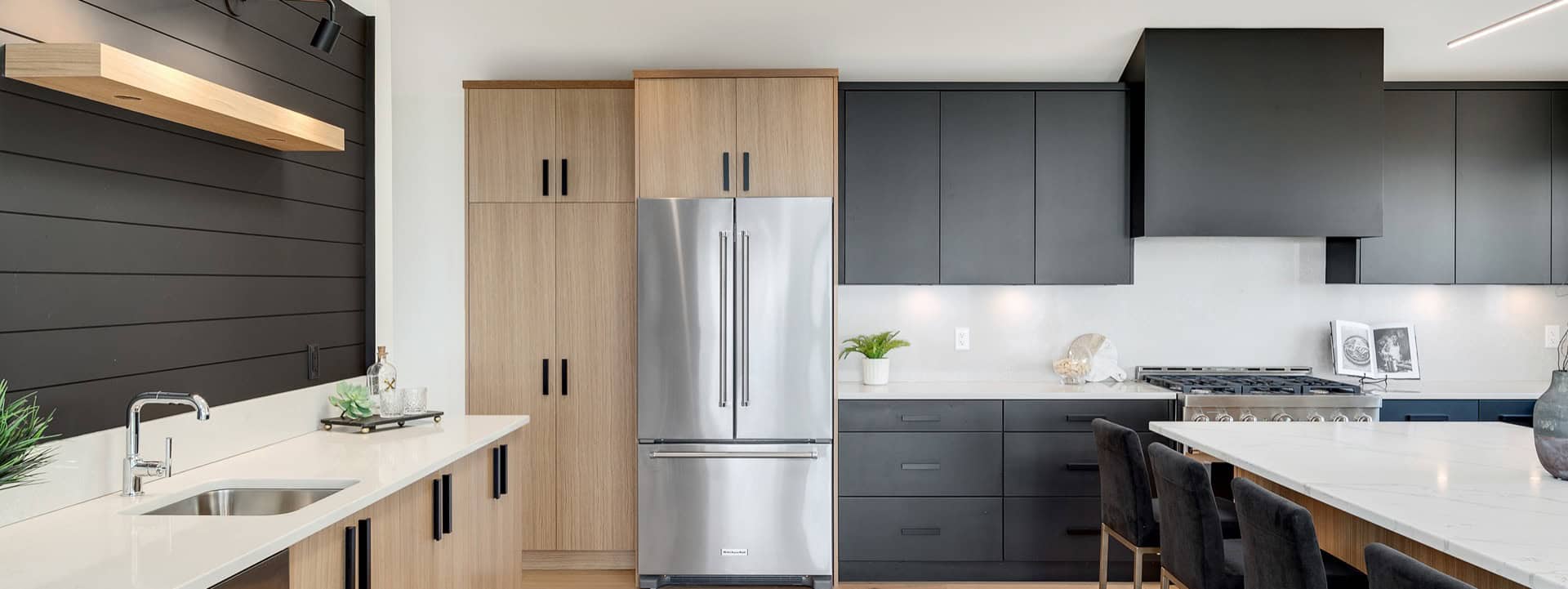 Modern Victoria BC kitchen by White Wolf Homes with dark cabinets and stainless appliances.