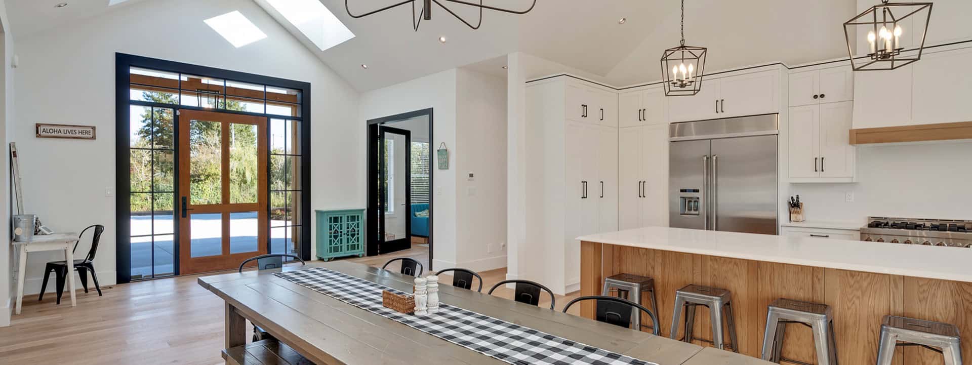 Modern kitchen with white cabinets, island, and skylights in View Royal Victoria BC.