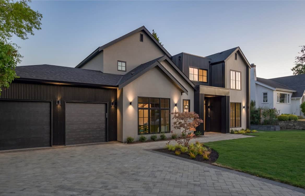 Modern luxury home by White Wolf Homes in Victoria BC with dark garage doors and landscaped front.