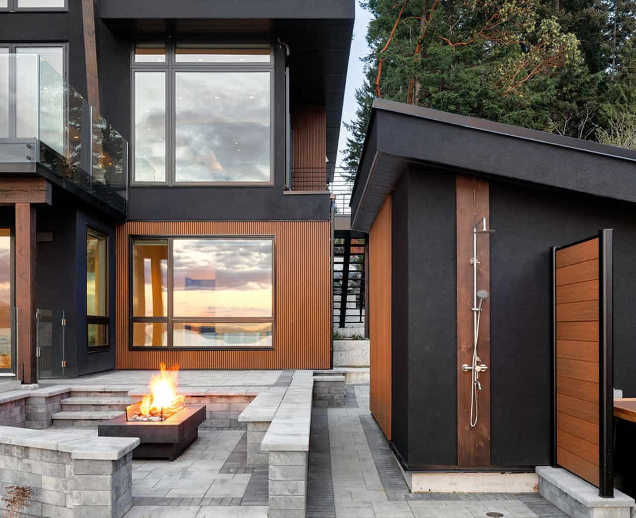 Modern Victoria BC home by White Wolf Homes with fire pit and dark facade.