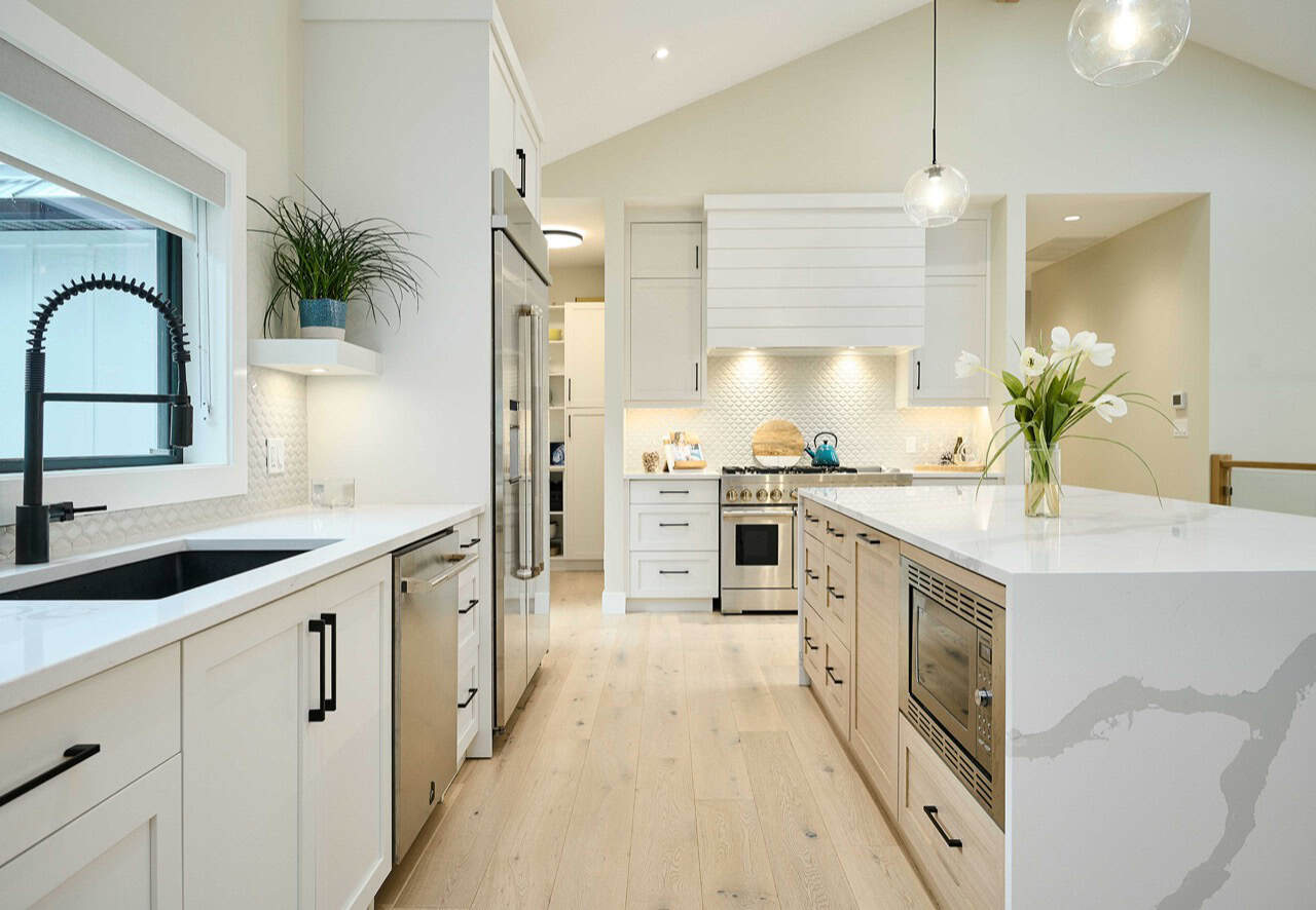 Modern white kitchen by White Wolf Homes in Langford, Victoria BC with island, stainless appliances,.