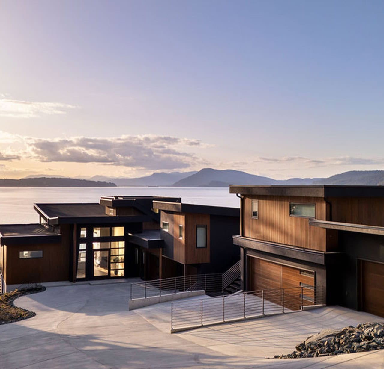 Modern waterfront home by White Wolf Homes in Victoria BC with wooden facades and coastal backdrop.
