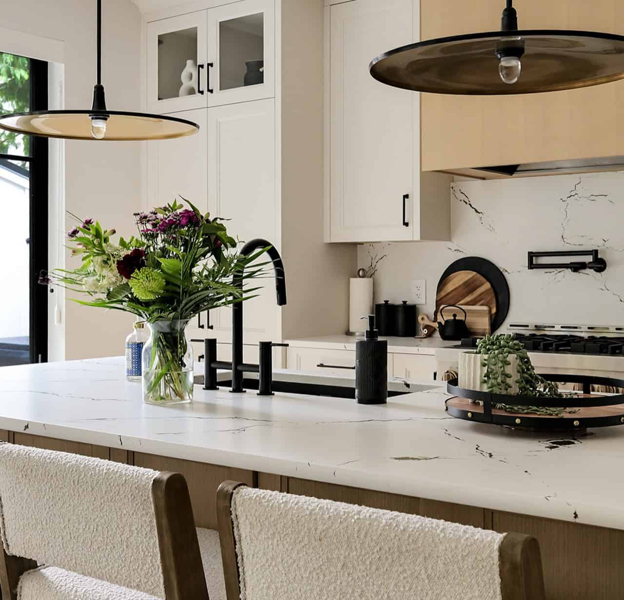 Modern kitchen by White Wolf Homes Victoria BC with white cabinets and marble countertops.