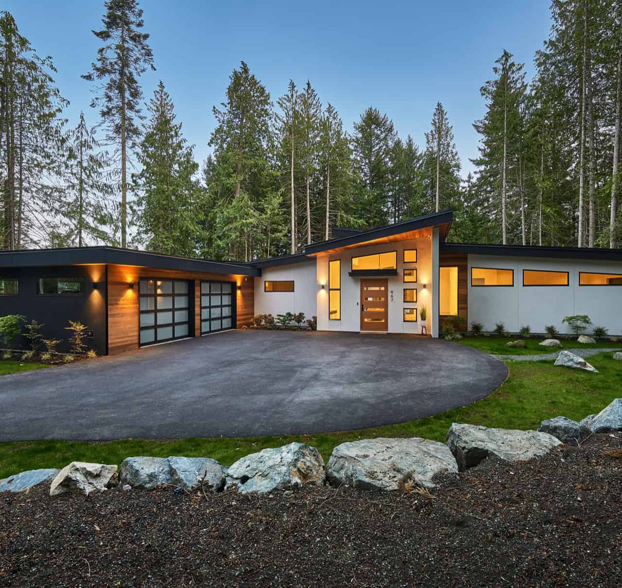 Modern custom home by White Wolf Homes on Victoria Island with expansive driveway and wooded setting.