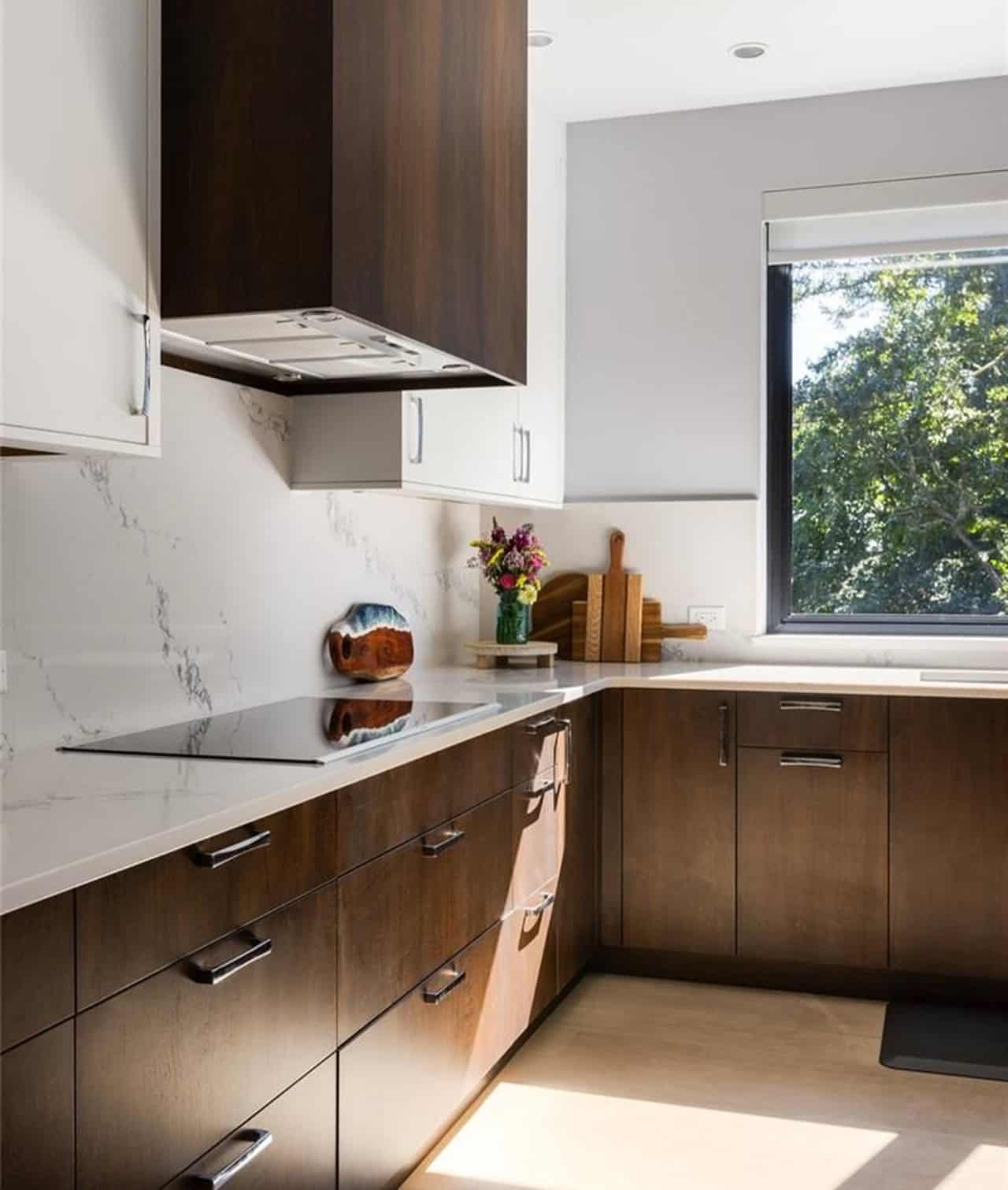 Modern kitchen with dark wood cabinets and marble backsplash in Victoria BC.