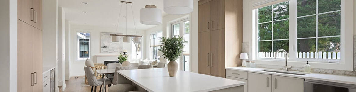 Modern bright kitchen with island, white cabinets and large windows.