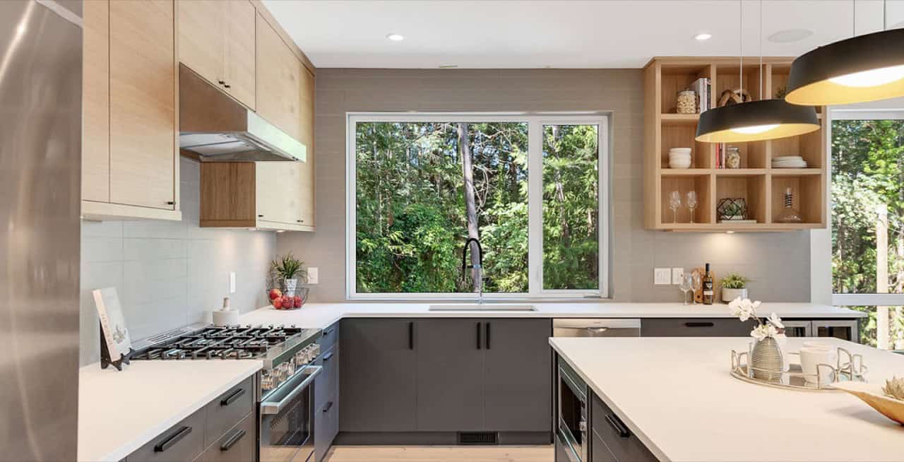Modern kitchen with large window, grey cabinets, and island at Baylight project.