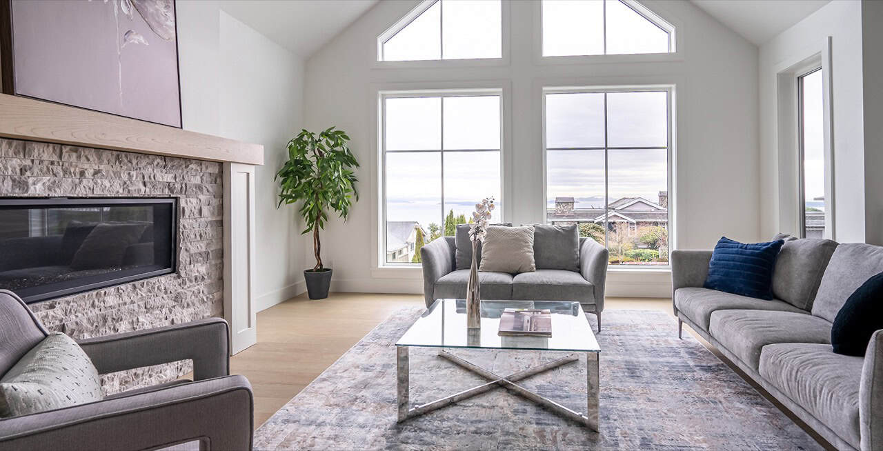 Bright living room with large windows, modern furniture and a view of outdoors.