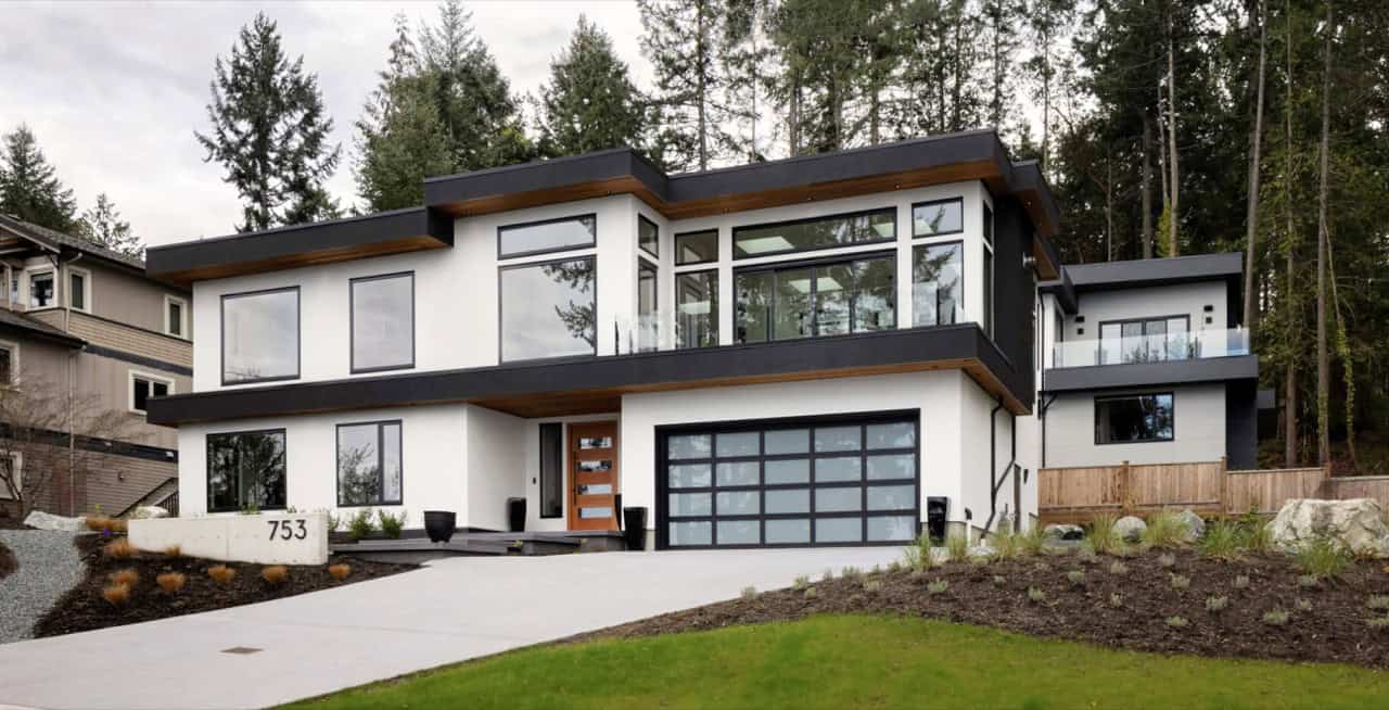 Modern custom home by White Wolf Homes in Victoria BC with large garage and glass facade.