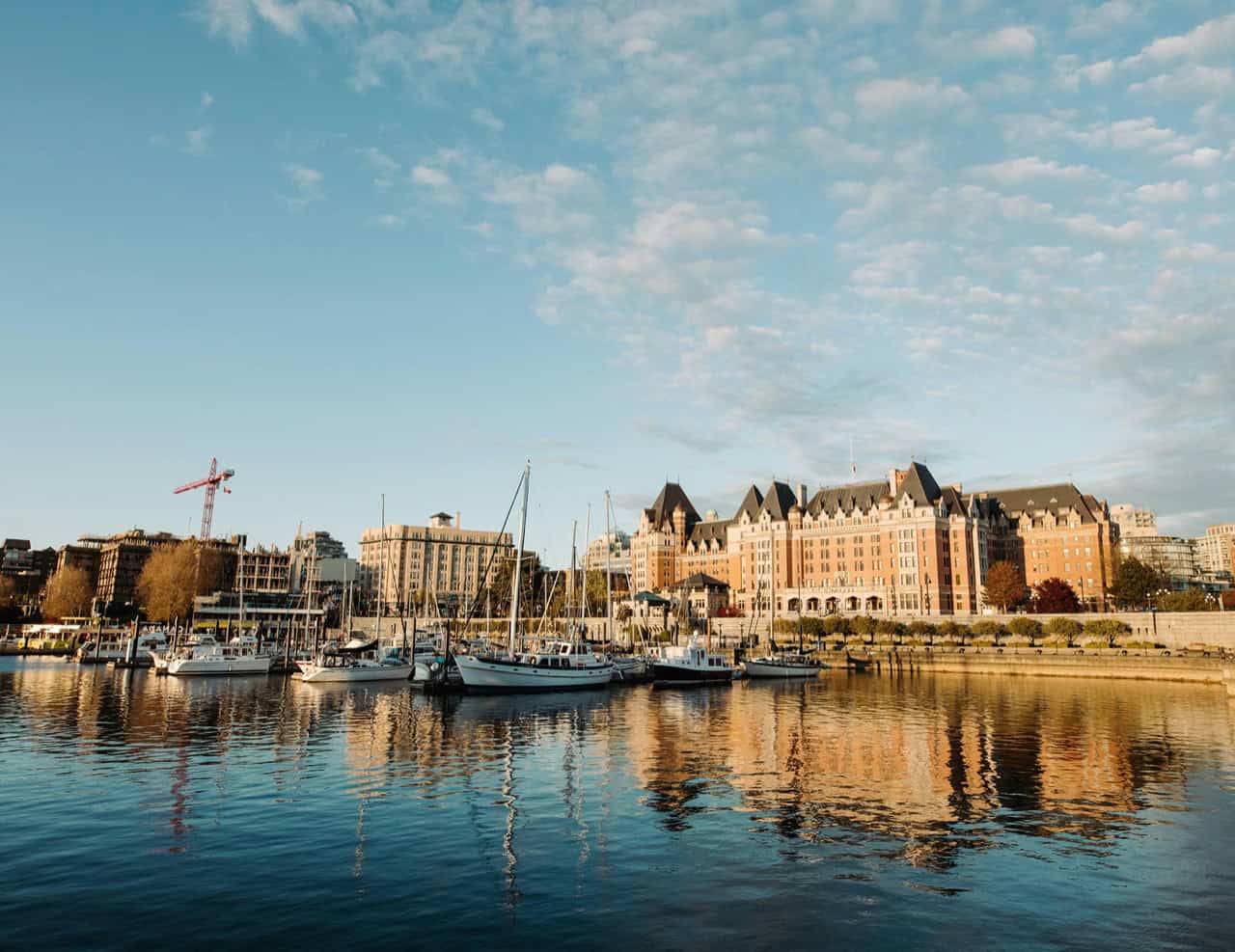 Victoria BC harbor with boats and buildings at sunset for White Wolf Homes.