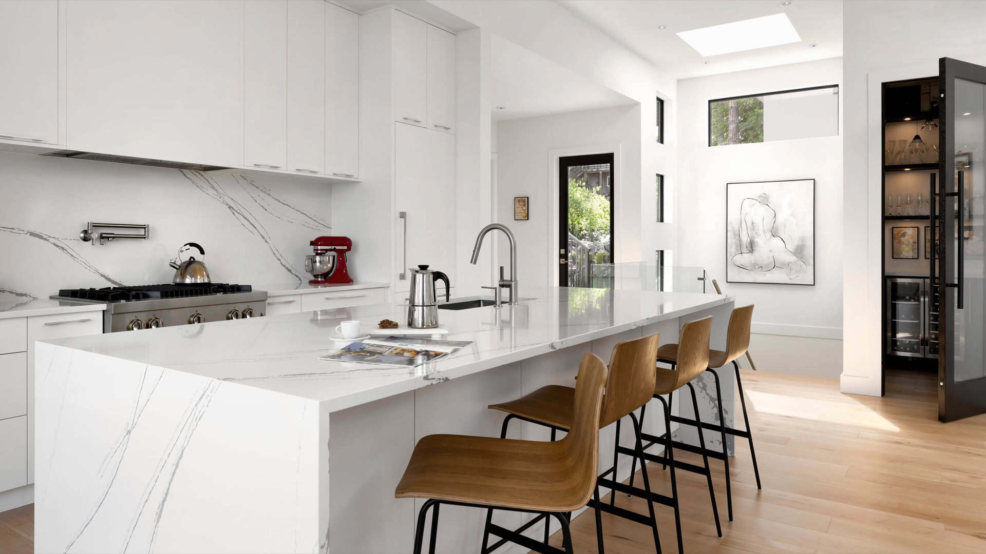 Modern white kitchen with marble countertops and wooden bar stools by Baylight.