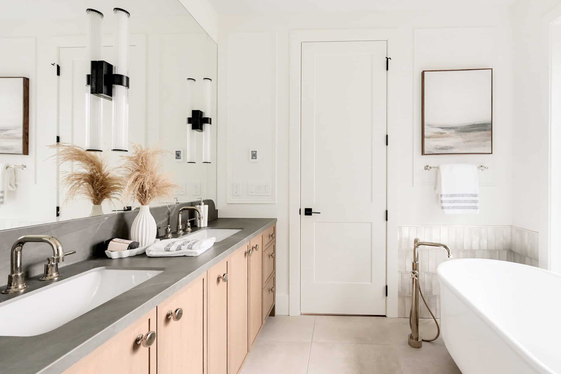 Bright, contemporary bathroom with dual sinks and freestanding tub in Westwyn project by White Wolf,.