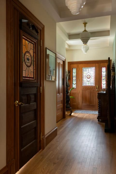 Virginia-style Victorian entry hallway with wooden doors and stained glass panels by White WolfHomes.