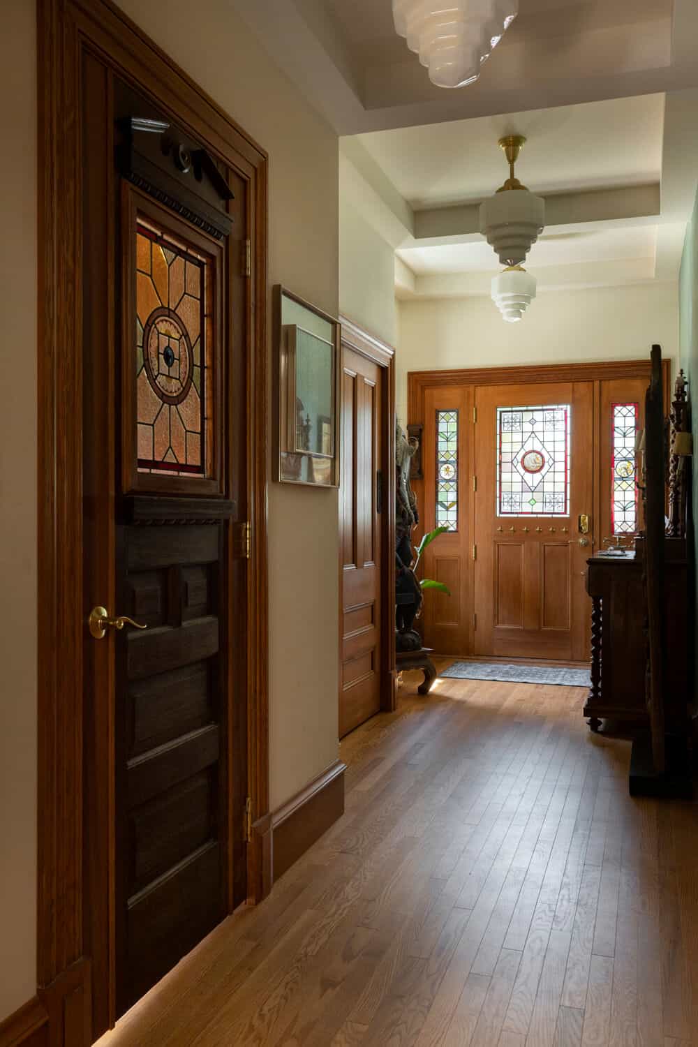 Virginia-style Victorian entry hallway with wooden doors and stained glass panels by White WolfHomes.