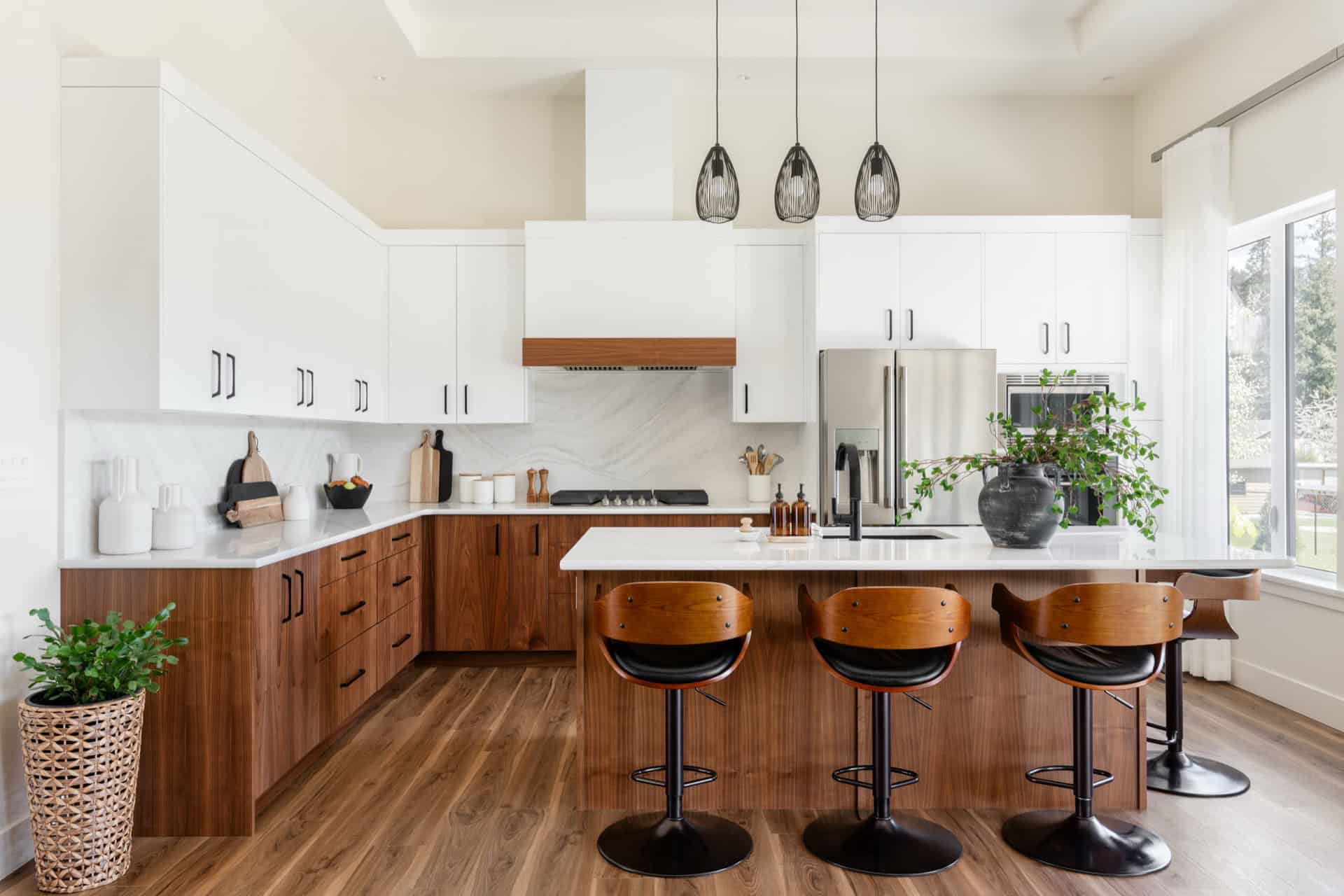Modern white and wood kitchen with island, pendant lights and bar stools in Victoria BC.