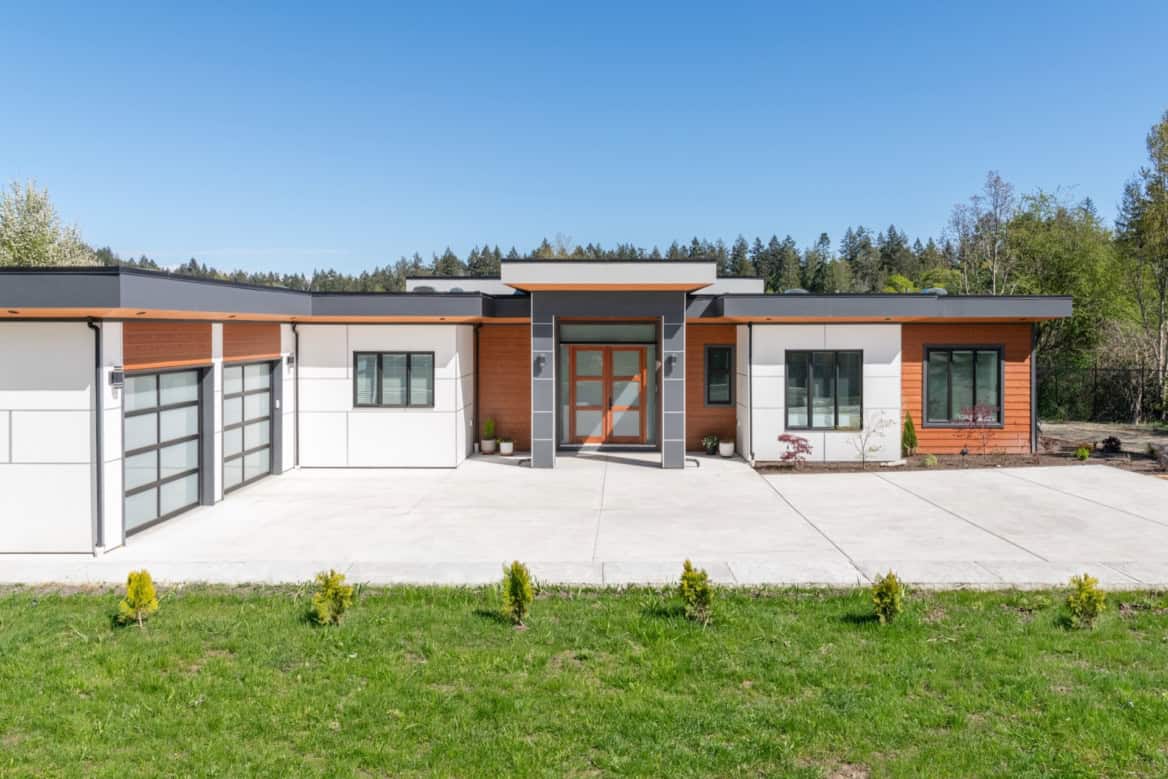 Modern ranch-style home by White Wolf Homes with a spacious driveway and manicured lawn.