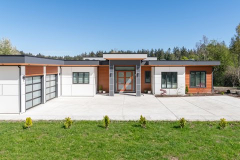 Modern ranch-style home by White Wolf Homes with a spacious driveway and manicured lawn.