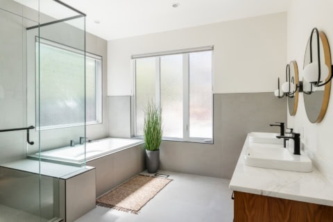 Modern Victoria BC bathroom with glass shower, tub, double vanity and neutral tones.