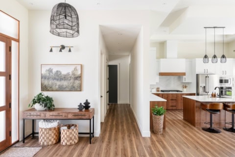 Bright open living space with entry hallway, wooden floor, and modern kitchen in Victoria BC home by.