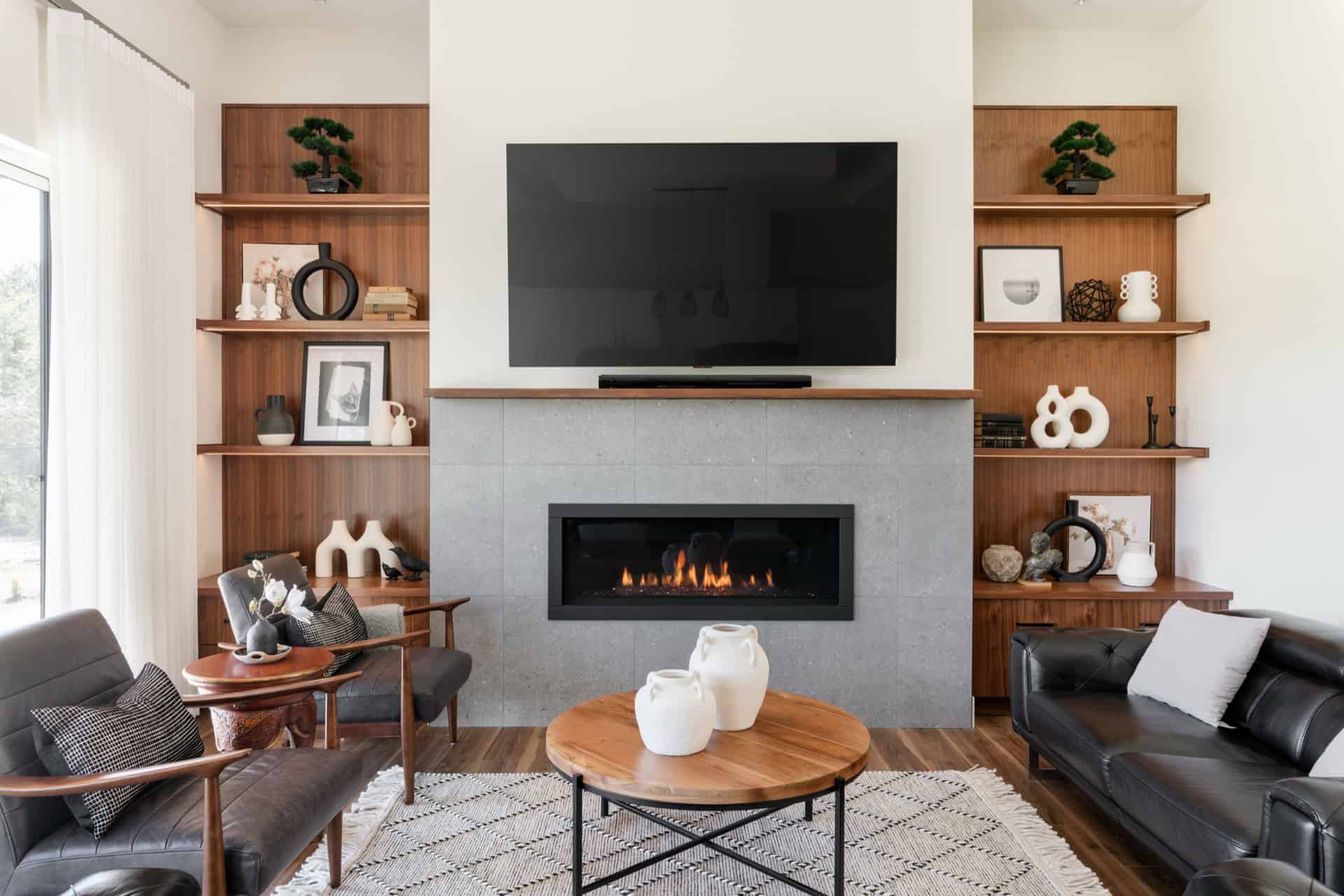 Living room with modern fireplace and built-in wooden shelves at White Wolf Homes site Victoria BC.