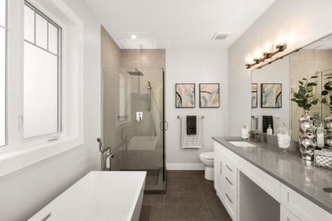 Modern bathroom design with glass shower, double vanity and neutral tones.