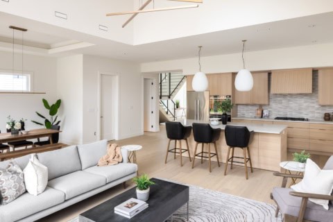 Bright open-concept living room and kitchen with modern white and wood finishes in a new Victoria BC.