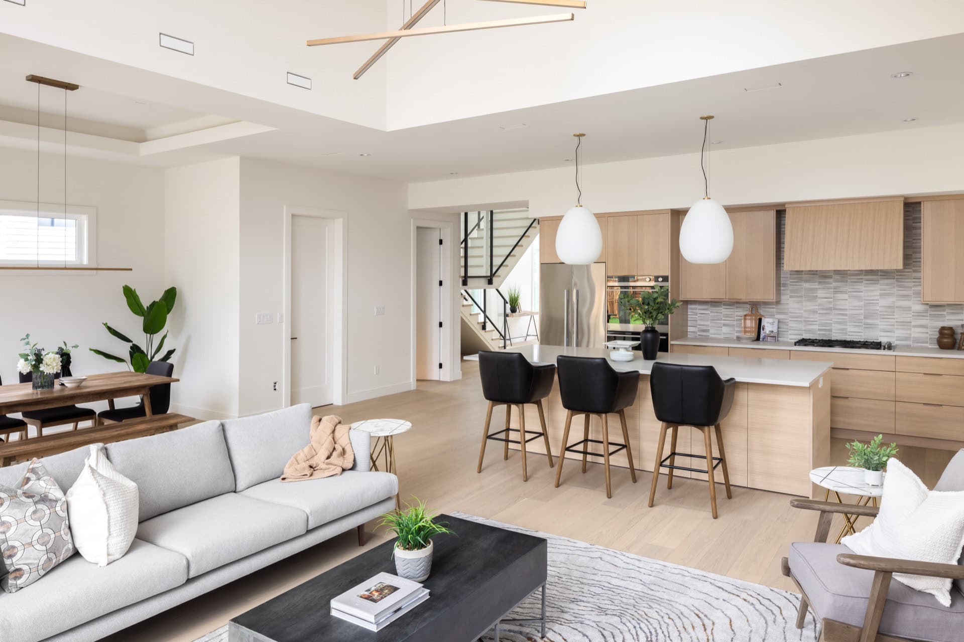 Bright open-concept living room and kitchen with modern white and wood finishes in a new Victoria BC.