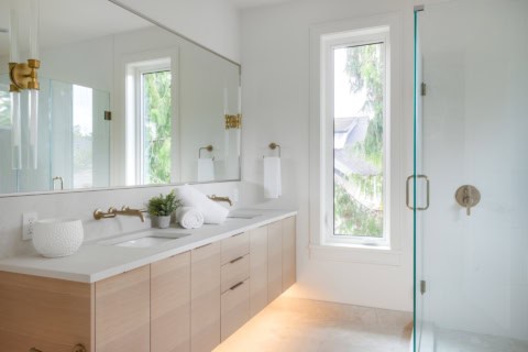 Modern ensuite bathroom with double vanity and glass shower.