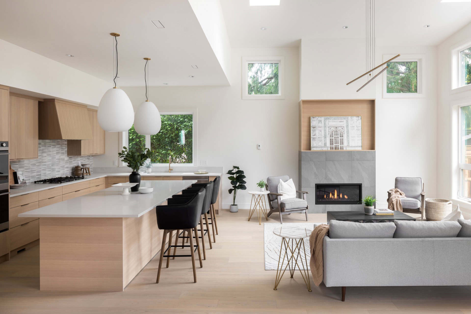 Bright open-concept kitchen and living area with large windows and modern decor.