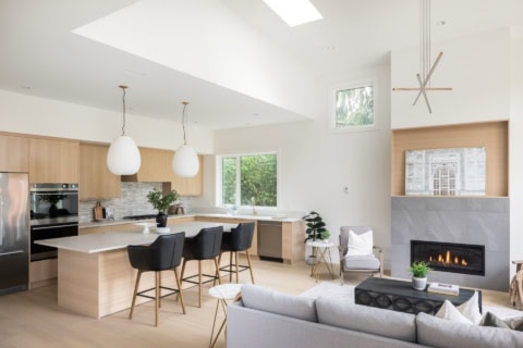 Elegant open-concept kitchen and living area with modern fireplace and island.