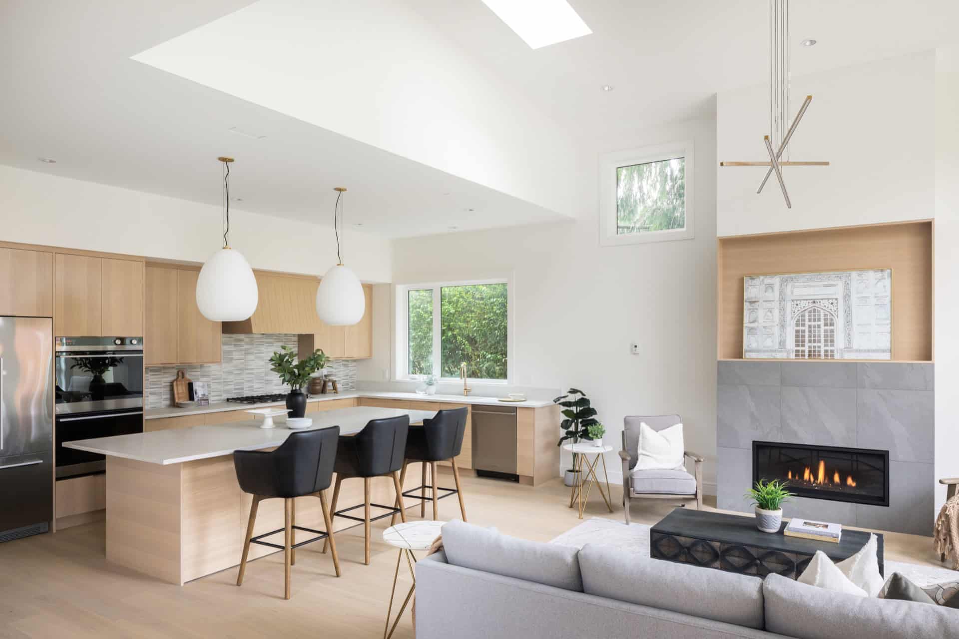Elegant open-concept kitchen and living area with modern fireplace and island.