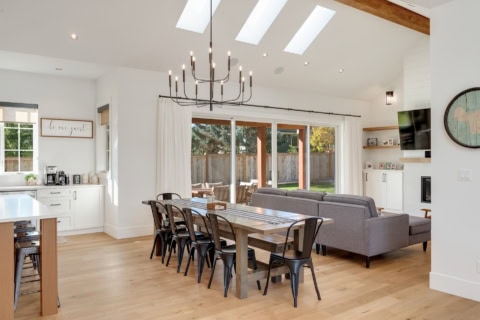Open-plan living and dining area with natural light, wooden floors, and modern furnishings in a home.