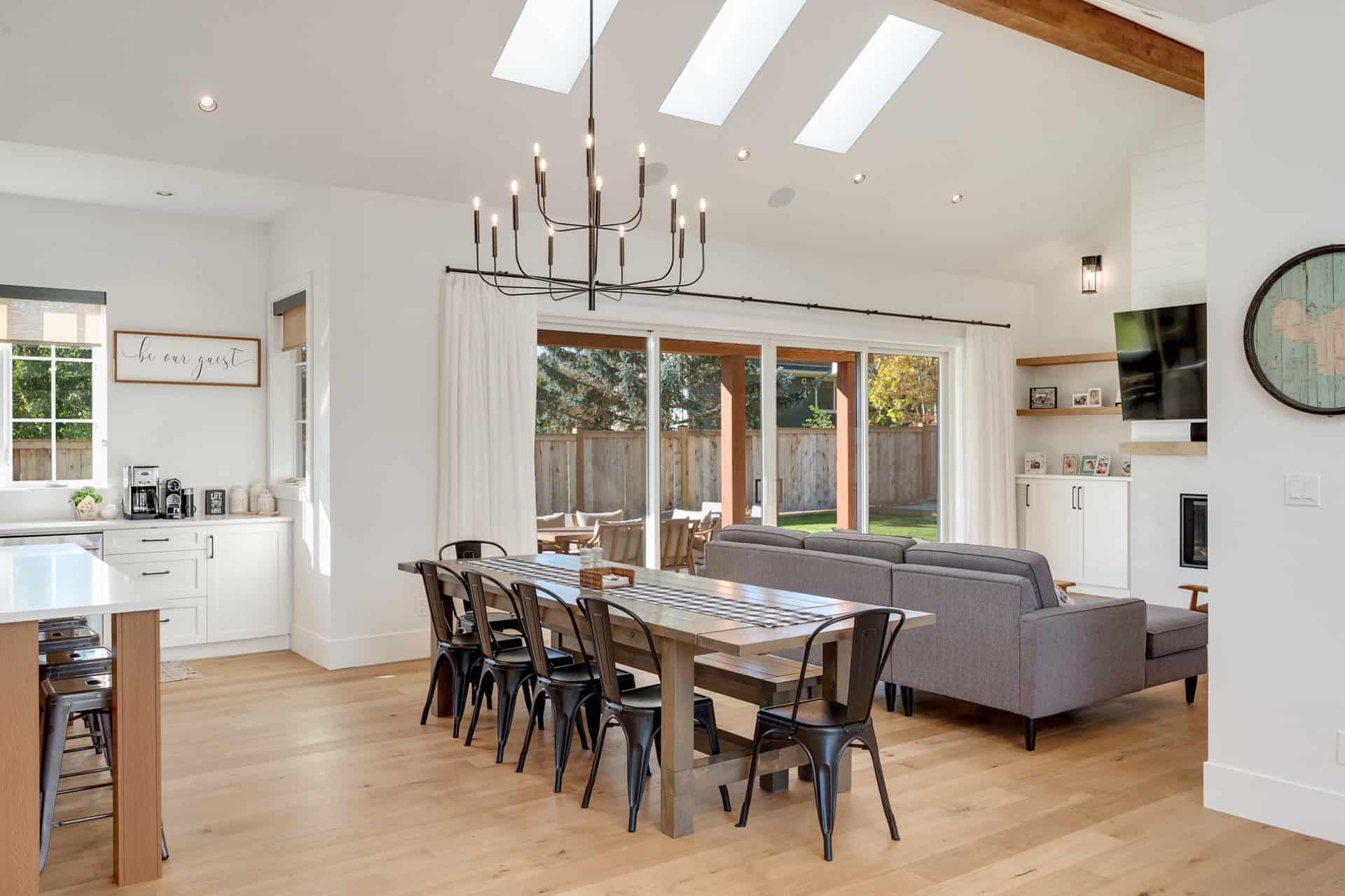 Open-plan living and dining area with natural light, wooden floors, and modern furnishings in a home.