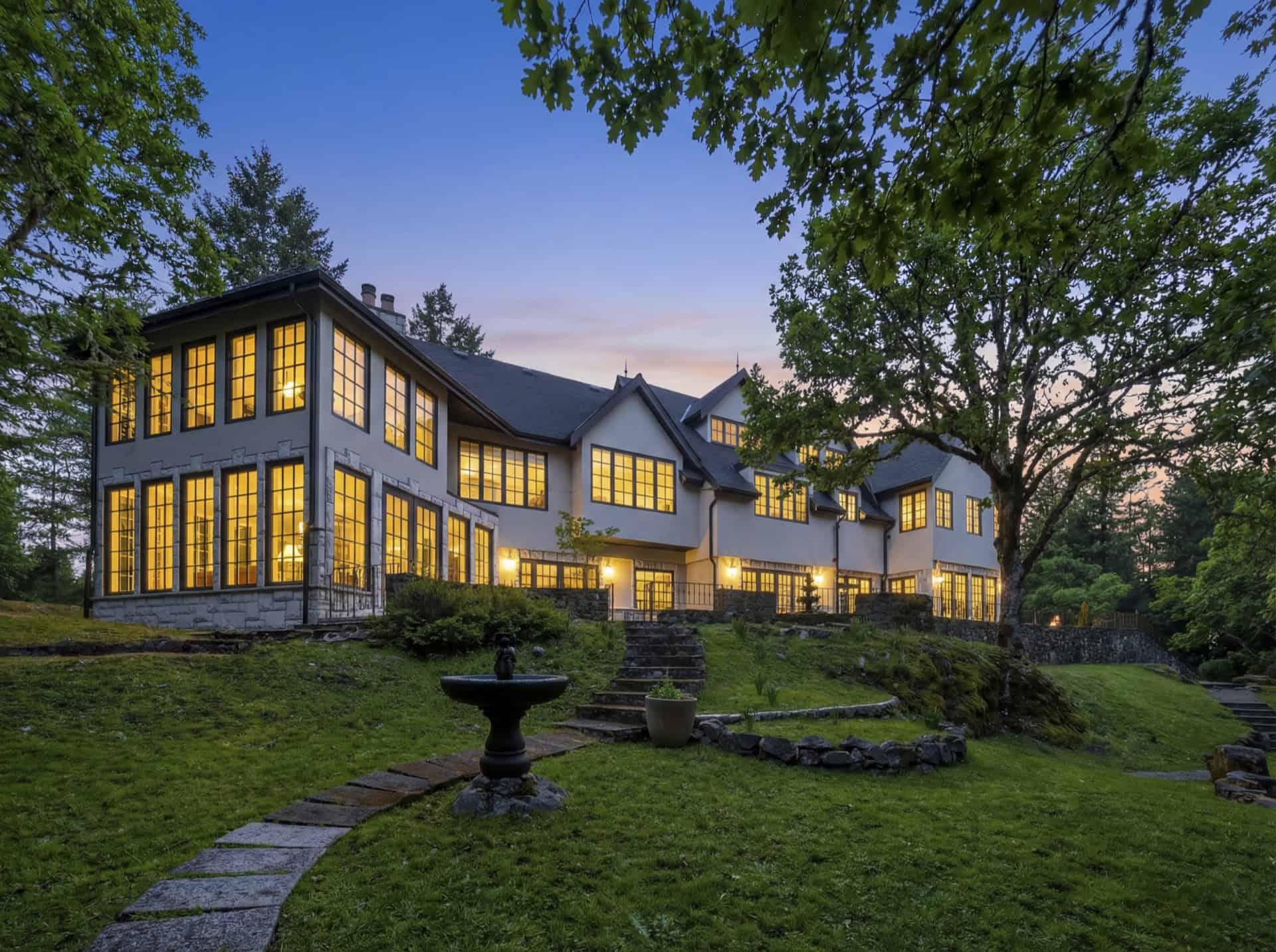 White Wolf Homes modern colonial-style home with illuminated windows at dusk, Victoria BC.