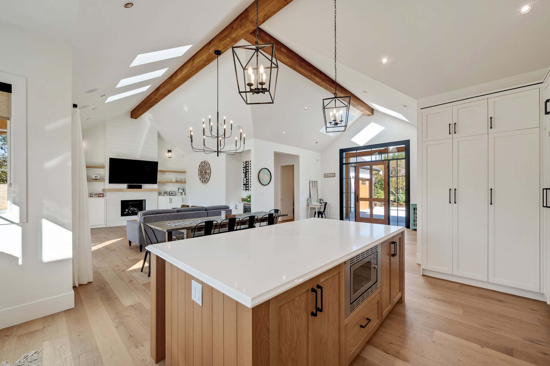 Open-concept kitchen with oversized island, vaulted ceiling, and modern lighting in a White Wolf Hom.
