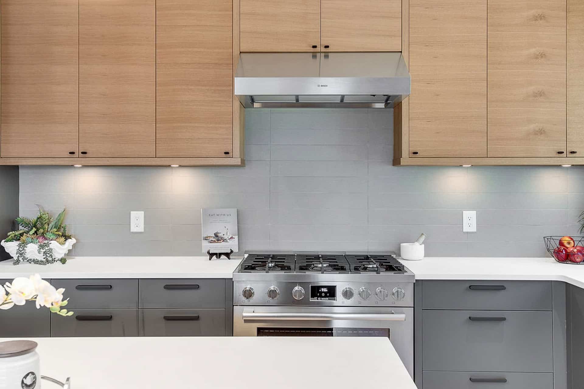 Modern kitchen by White Wolf Homes in Victoria BC with maple cabinets and stainless steel stove.