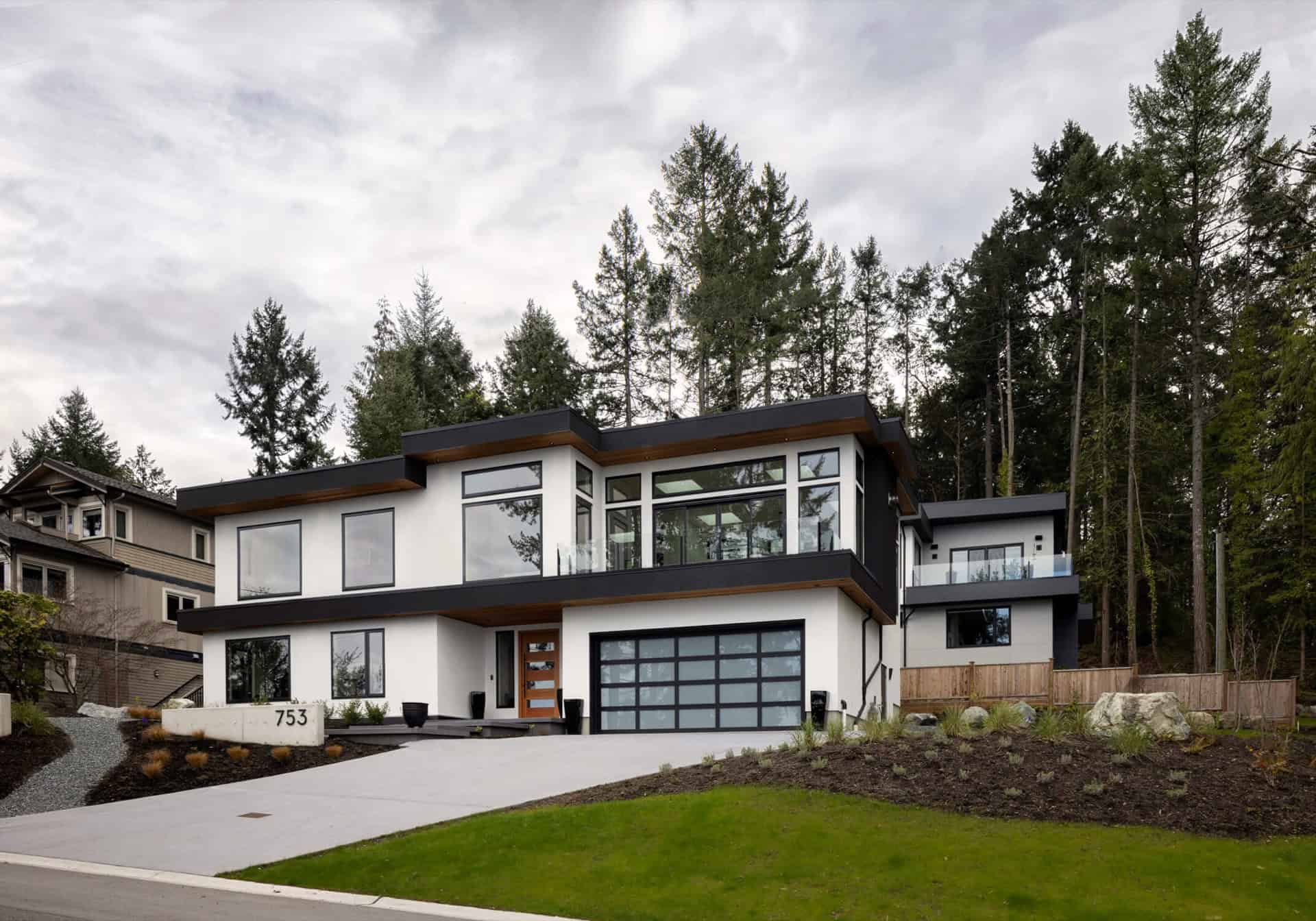 Modern two-story custom home by White Wolf Homes in Victoria BC with large glass windows.