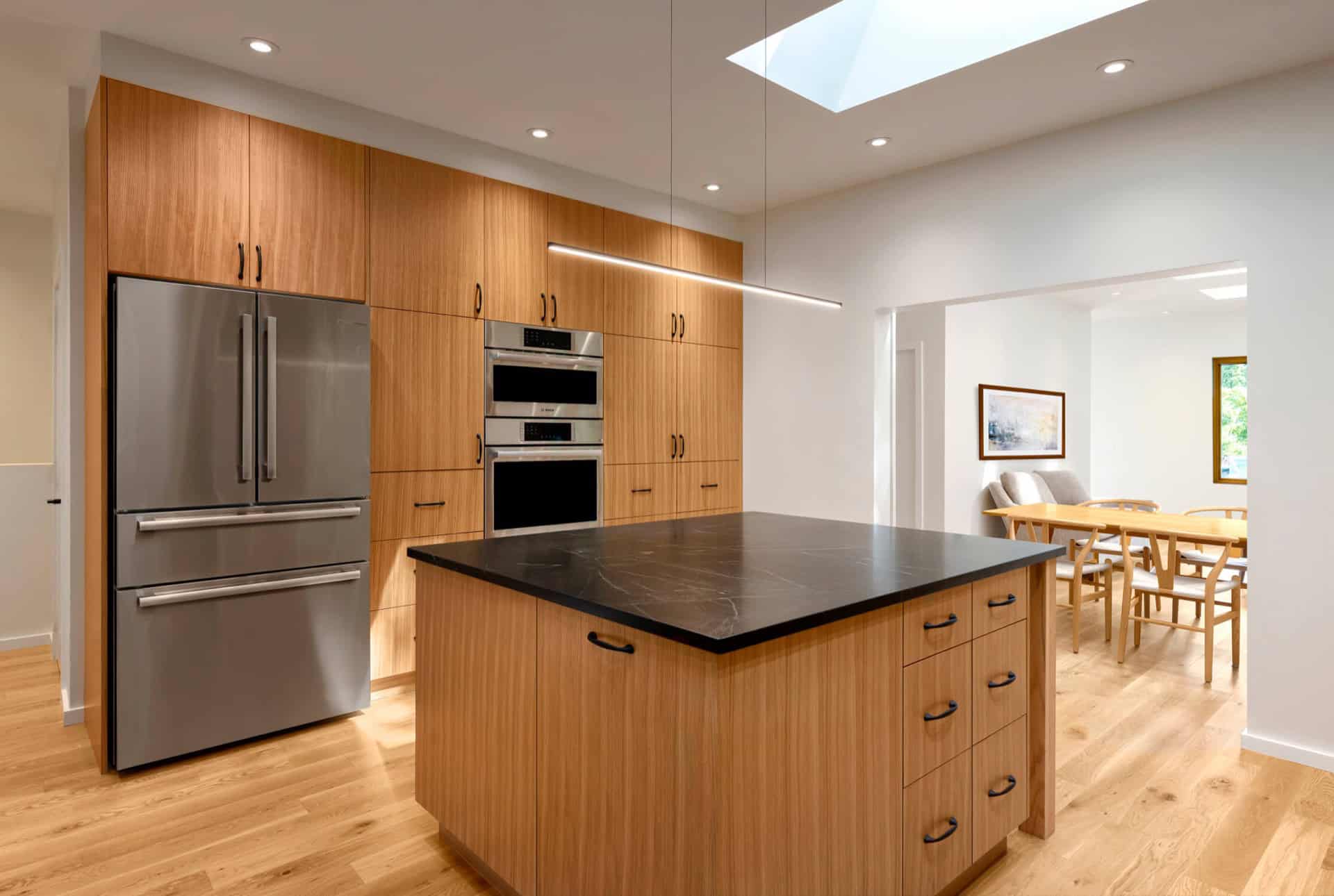 Modern kitchen with wooden cabinetry and island in Victoria BC home by White Wolf Homes.