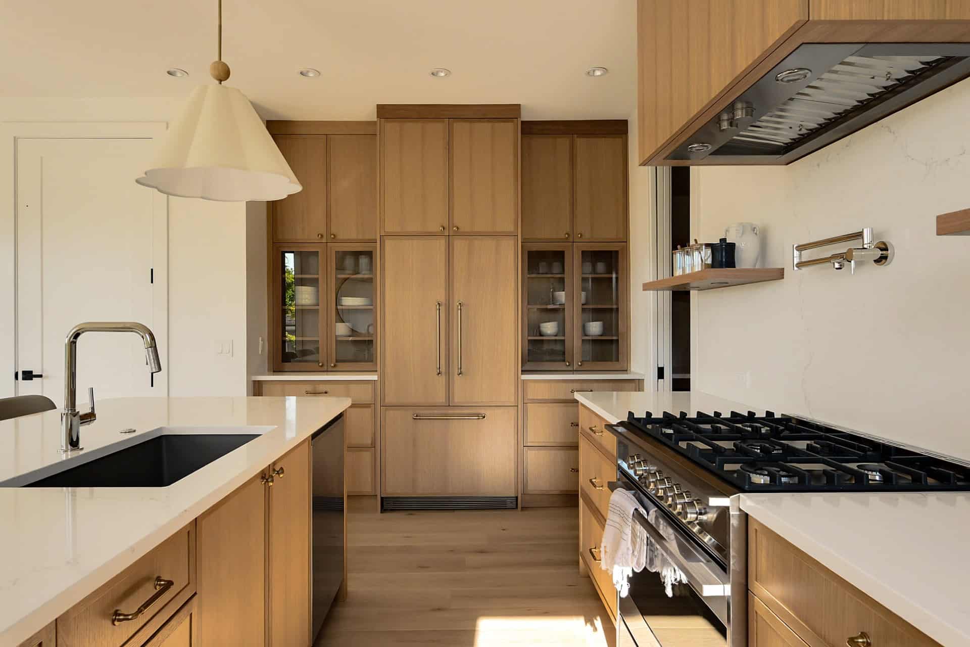 Luxurious oak kitchen with island, modern appliances and warm wood cabinetry.