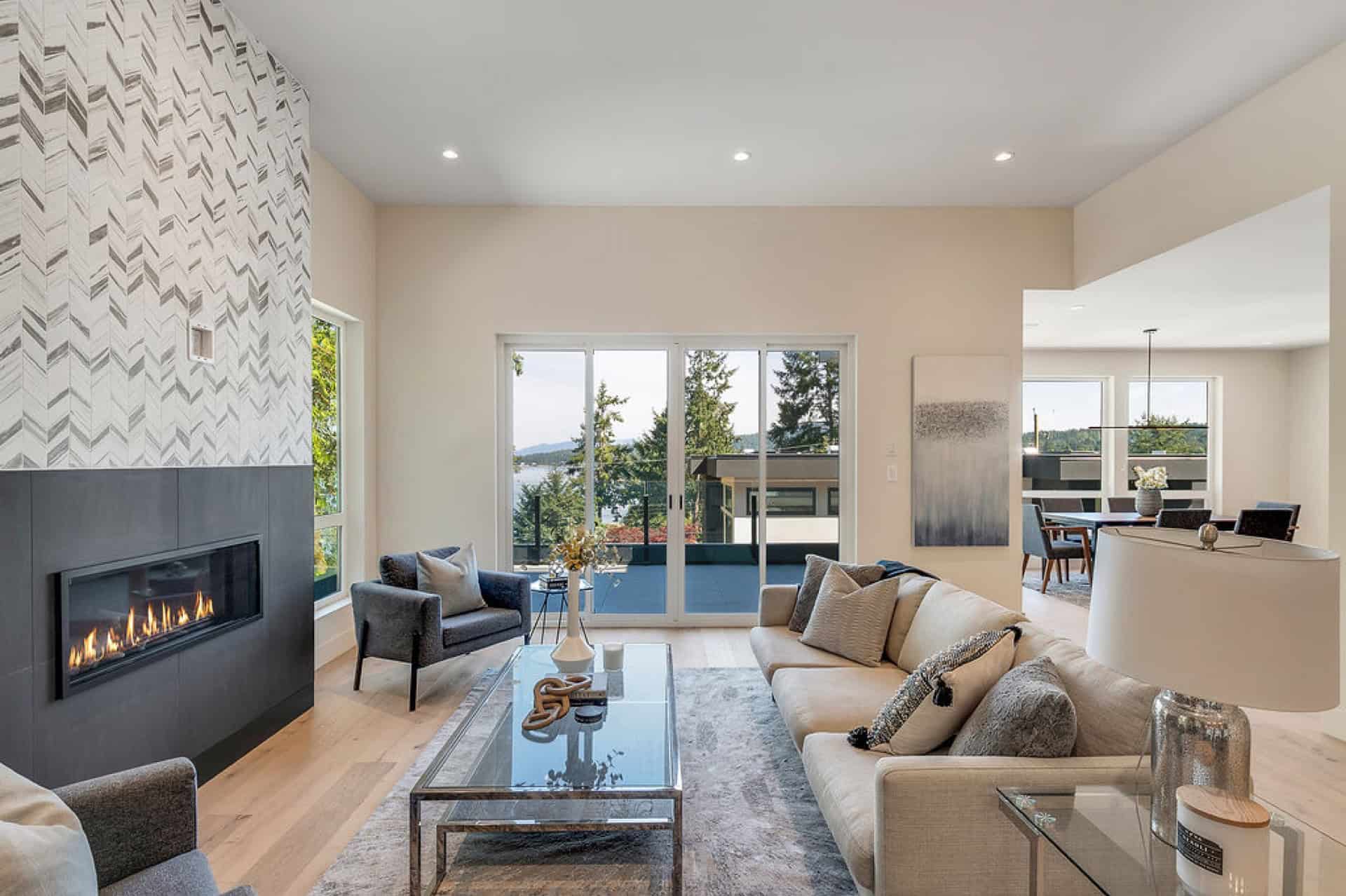 Living room with fireplace, modern seating, large windows showing outdoor scenery, and contemporary設.