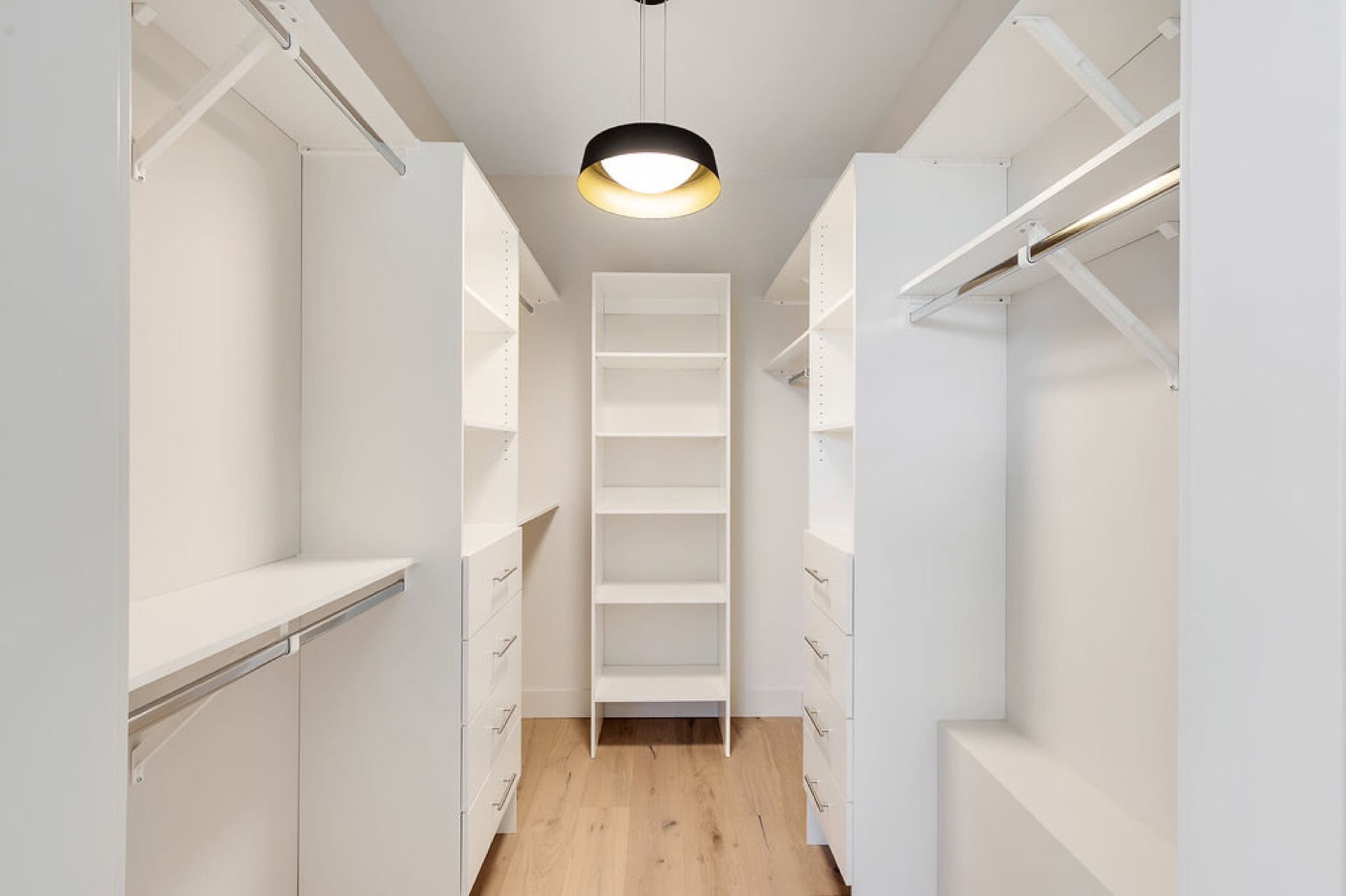 Spacious white walk-in closet with organized shelving and hanging rods.