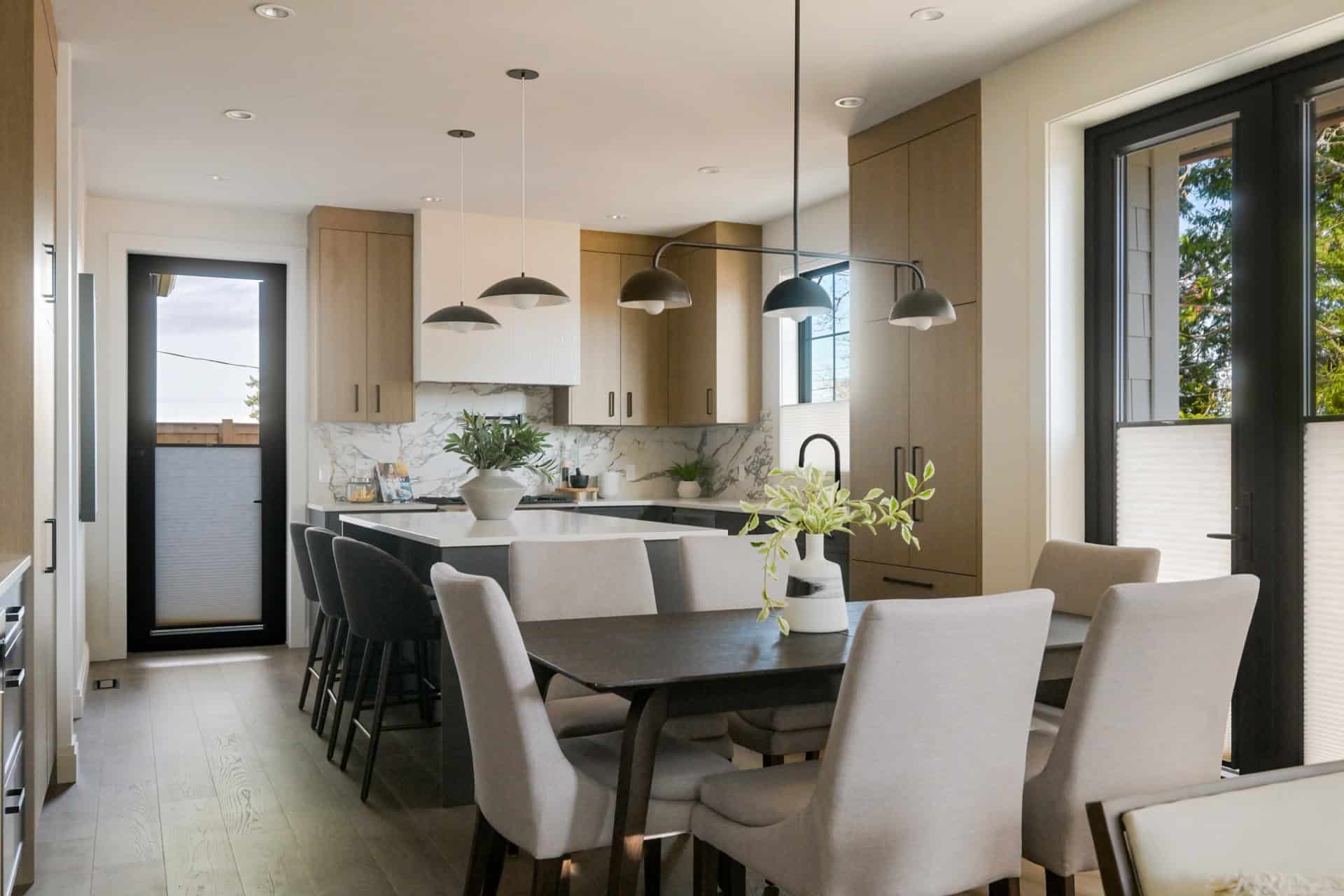 Modern kitchen with island, pendant lights, and dining area in Cedar & Stone project by White Wolf H.