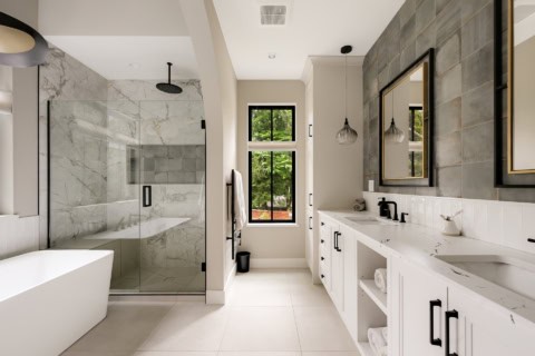 Modern ensuite bathroom with walk-in shower, freestanding tub, and double vanity by White Wolf Homes.