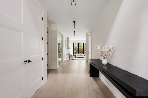 Bright hallway at White Wolf Homes with minimalist console and floral arrangement.