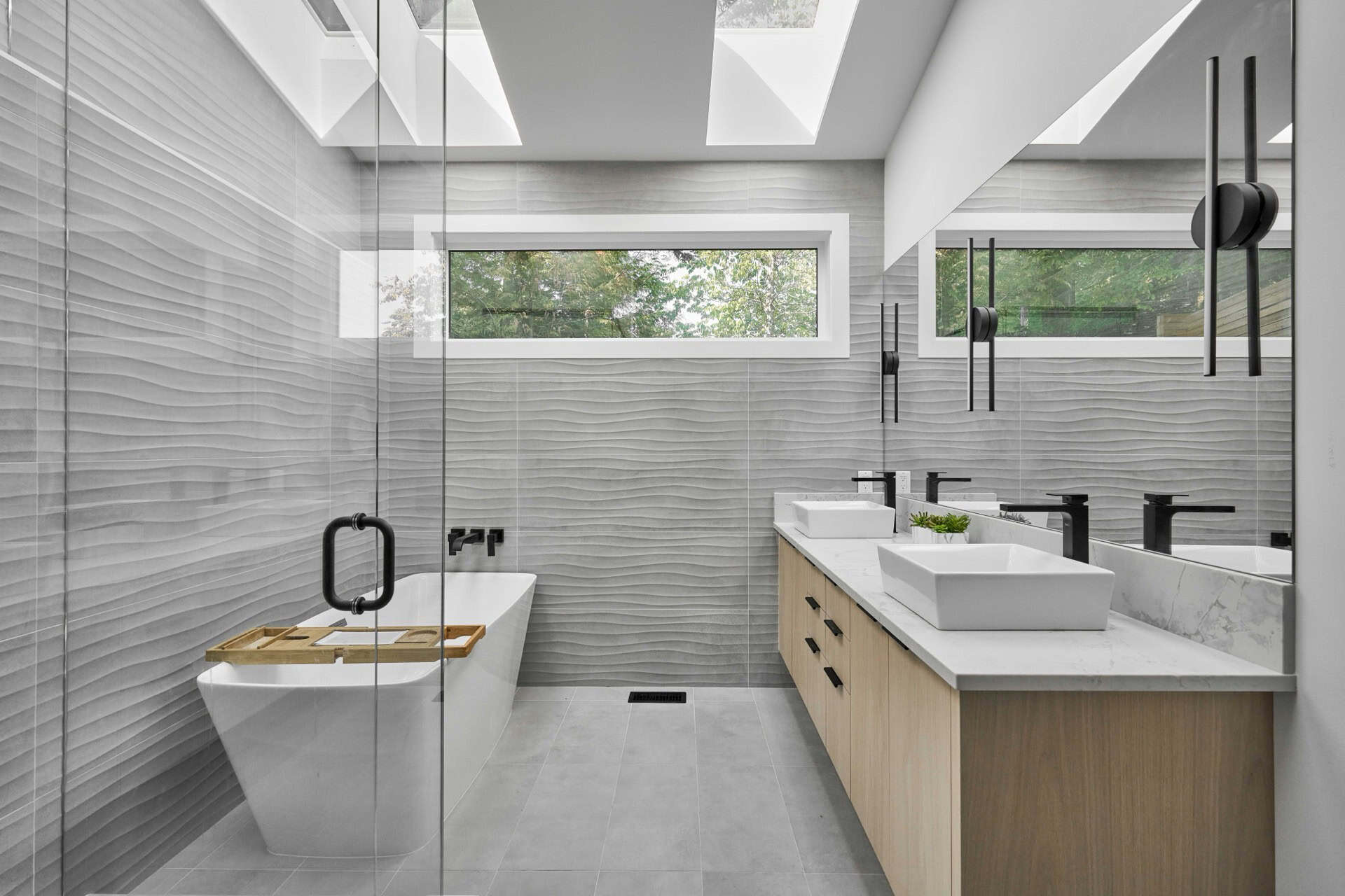 Contemporary bathroom with double vanity, freestanding tub, and glass shower enclosure.